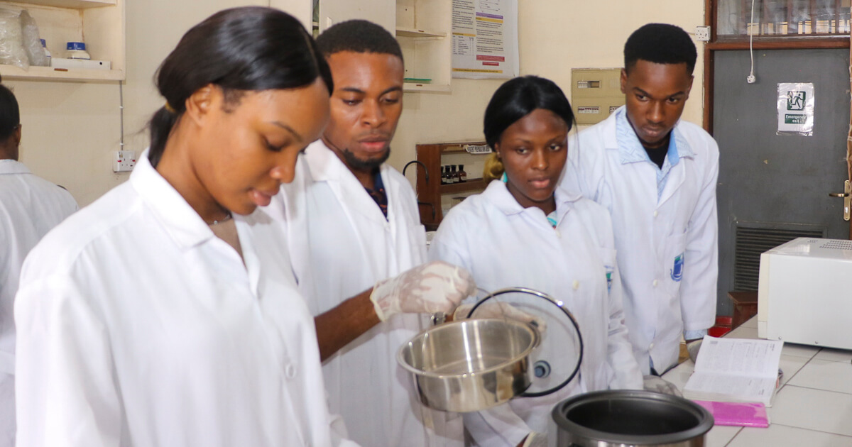 Plant Science and Biotechnology students screening cowpea grains for short cooking time with hand-held pH meter and pressure cooker