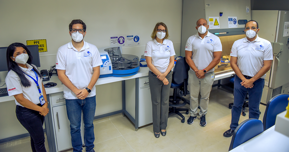 UNIBE researchers in the Institute of Tropical Medicine and Global Health, standing around the newly-installed automated RNA extractor which will significantly expand and accelerate COVID-19 diagnostic testing in the Dominican Republic